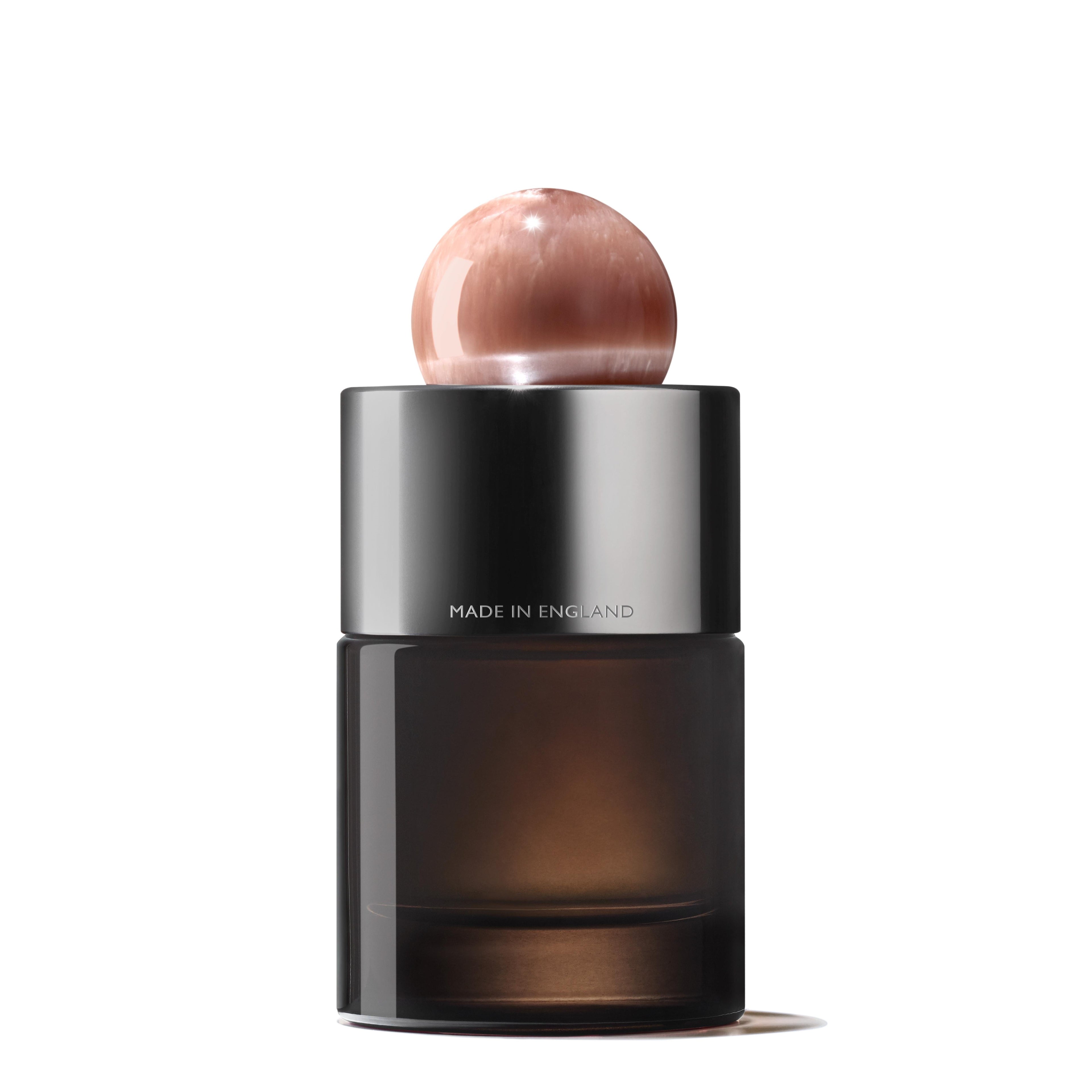 A sleek bottle of Heavenly Gingerlily Eau de Parfum 100ml by MoltonBrown Cyprus features a metallic base and a translucent, spherical cap. The label states Made in England. This fragrance showcases a modern, minimalist design with a dark gradient finish, evoking an exotic escape with its alluring notes of Heavenly Gingerlily.