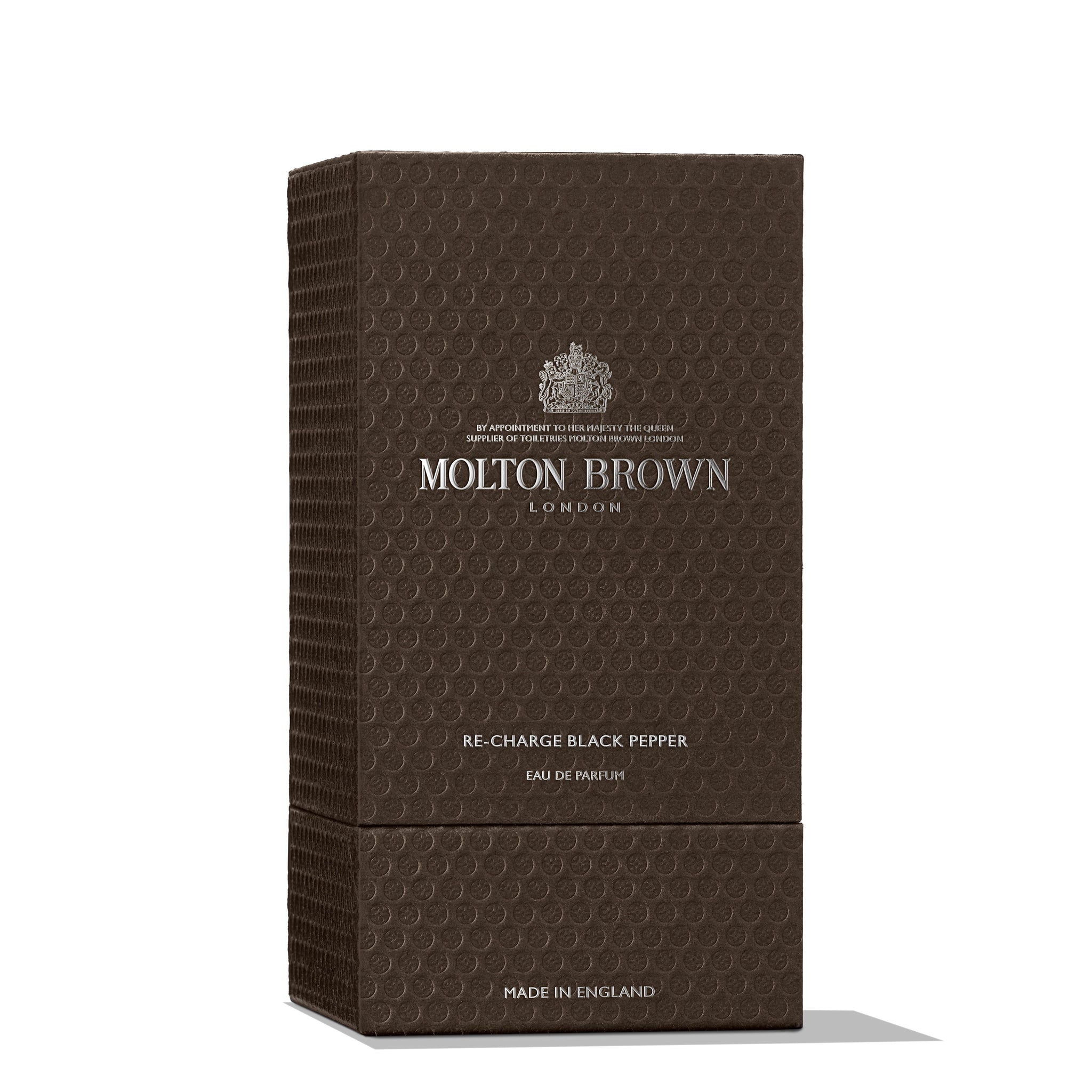 A rectangular box with a textured brown finish features the MoltonBrown Cyprus logo prominently at the top. The text describes Re-charge Black Pepper, Eau de Parfum, which includes notes of vetiver. This patterned-surface box is made in England.