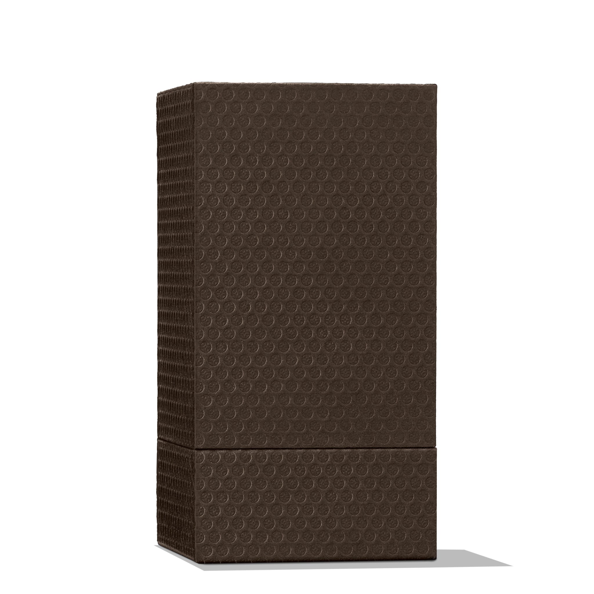 A rectangular, dark brown textured box with a bubble wrap-like pattern suggests the luxurious contents of Orange & Bergamot Eau de Parfum 100ml by MoltonBrown Cyprus. It stands upright on a white background, casting a gentle shadow to the right and evoking the whisper of musky-woods and orange flower notes.