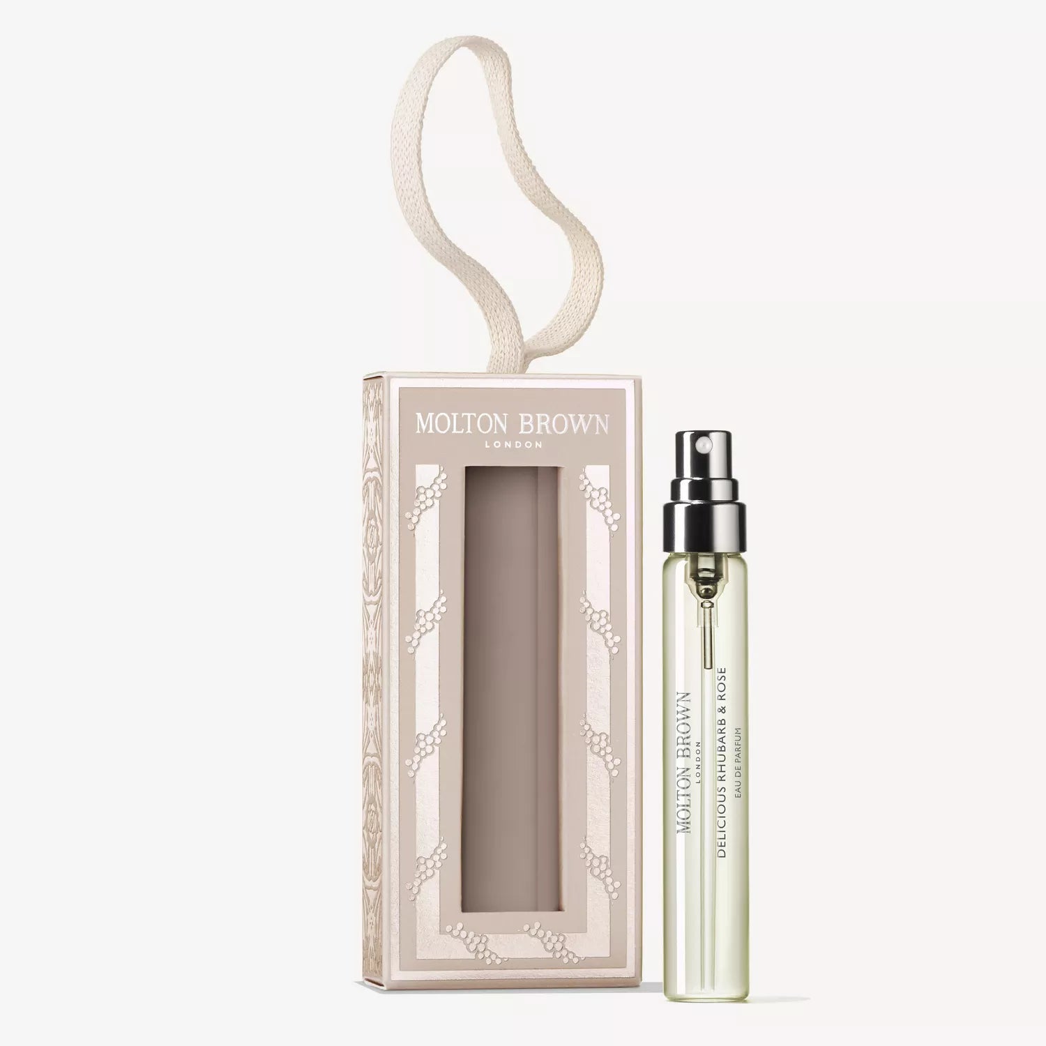 A clear MoltonBrown Cyprus Delicious Rhubarb & Rose Fragrance Bauble 7.5ml stands beside its beige, rectangular box with a cut-out window and looped ribbon handle. The scent features notes of rhubarb, rose, and touches of peony.