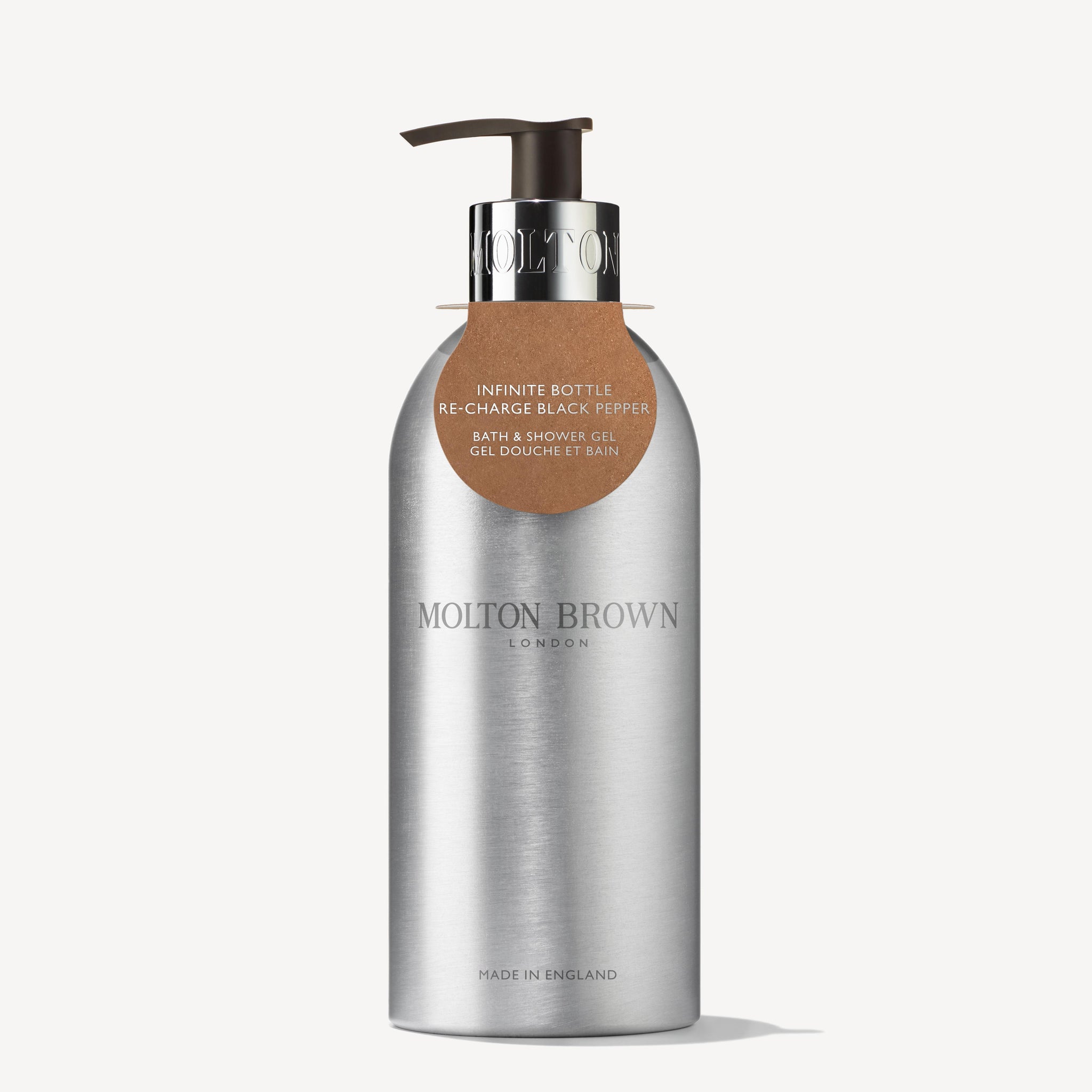 The Re-charge Black Pepper Infinite Bottle 400ml from MoltonBrown Cyprus is a sleek container crafted from recycled aluminum. Featuring a silver finish and a metal pump, it dispenses the woody-citrus blend of Re-charge Black Pepper bath and shower gel. The label, presented in both English and French, emphasizes its aromatic qualities. Proudly made in England, it pairs perfectly with a waste-reducing refill pouch.