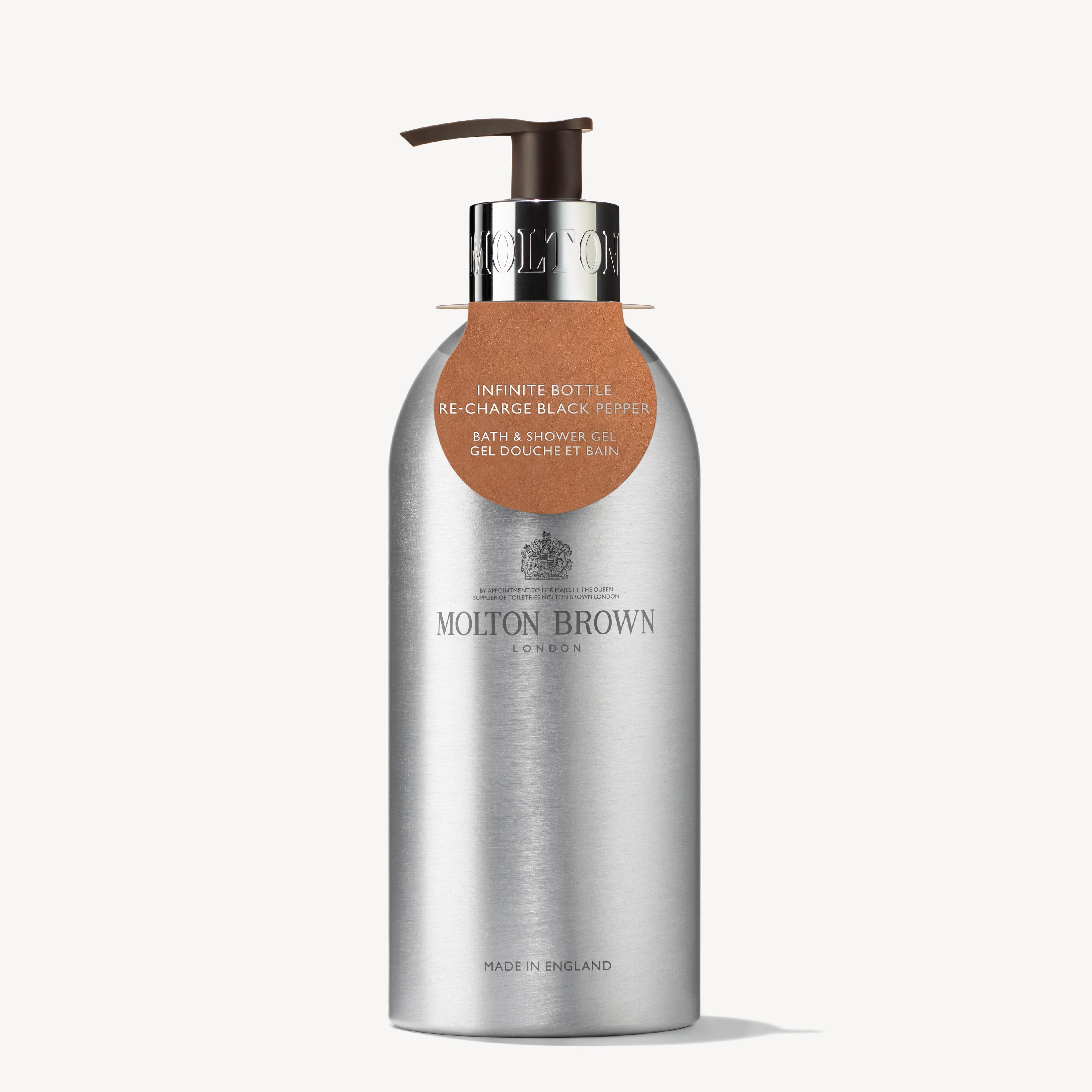 The Re-charge Black Pepper Infinite Bottle 400ml from MoltonBrown Cyprus is a sleek container crafted from recycled aluminum. Featuring a silver finish and a metal pump, it dispenses the woody-citrus blend of Re-charge Black Pepper bath and shower gel. The label, presented in both English and French, emphasizes its aromatic qualities. Proudly made in England, it pairs perfectly with a waste-reducing refill pouch.