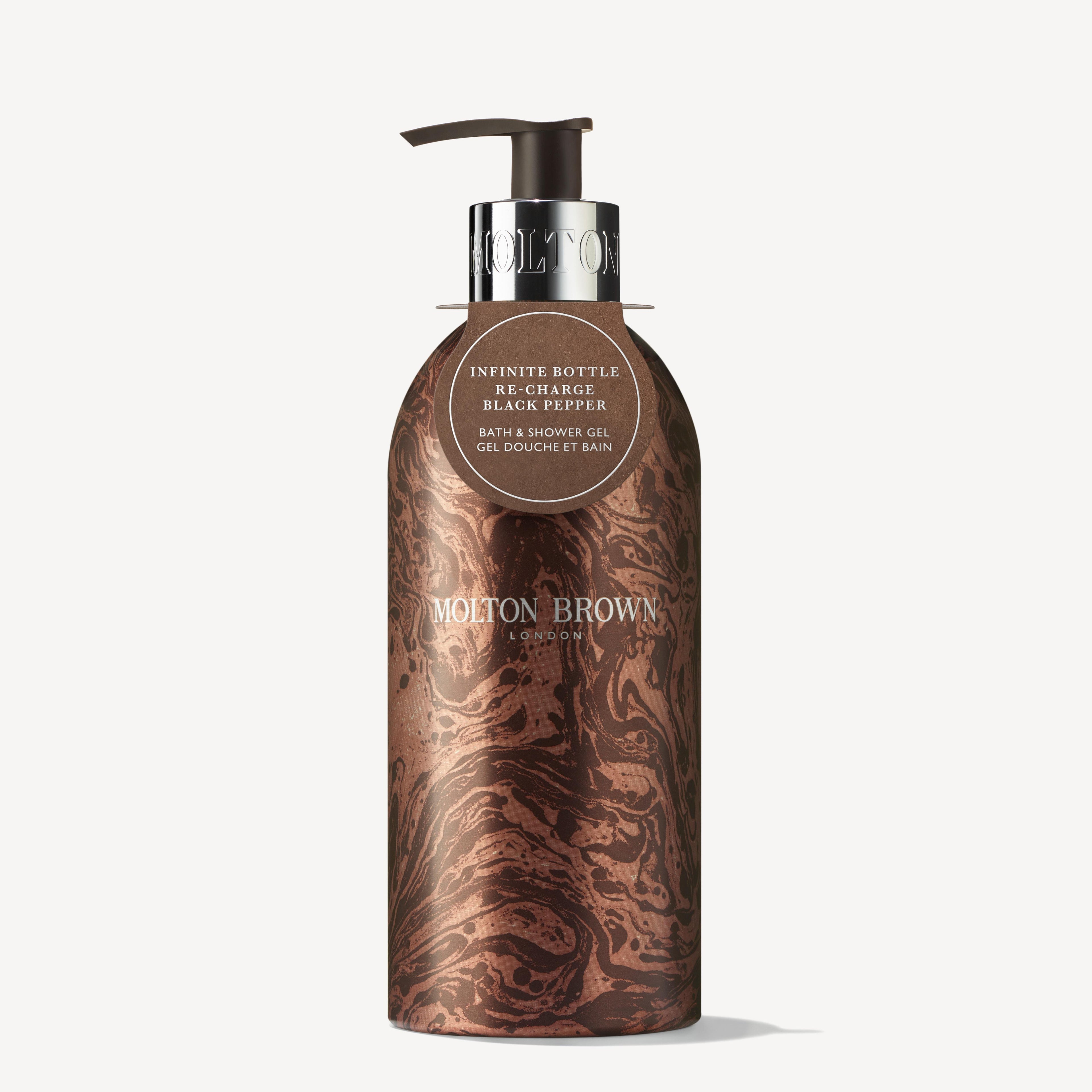 A marble-patterned, brown and black MoltonBrown Cyprus bottle with a pump exudes luxury. Bearing the label "Limited Edition Re-charge Black Pepper Infinite Bottle," it highlights its woody-citrus fragrance. This refillable shower gel bottle combines style with waste reduction.