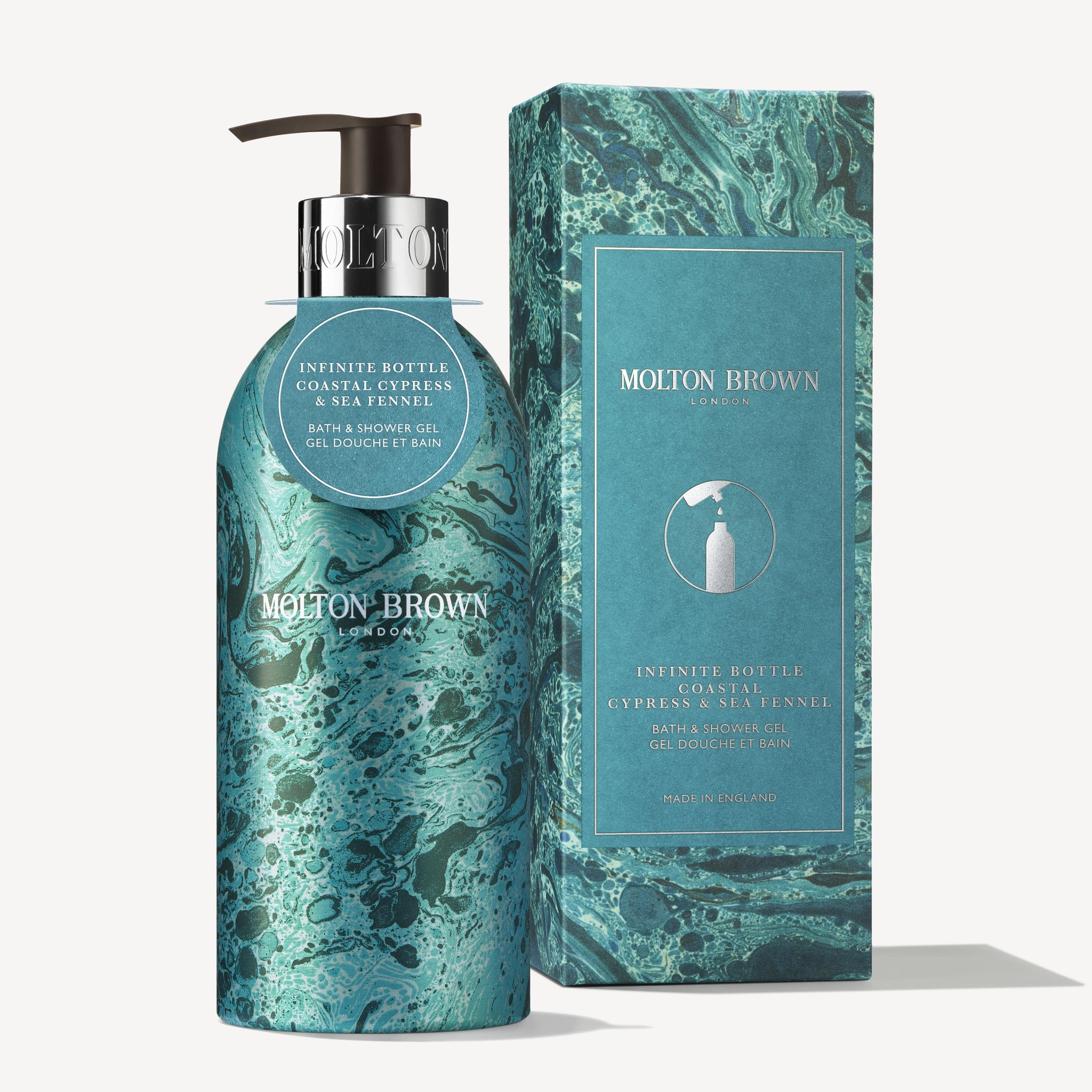 A MoltonBrown Cyprus bottle of bath and shower gel, named Limited Edition Coastal Cypress & Sea Fennel Infinite Bottle, is elegantly presented alongside its matching teal and blue marbled box. The aromatic fragrance label exudes style, enhanced by a sophisticated silver pump dispenser.