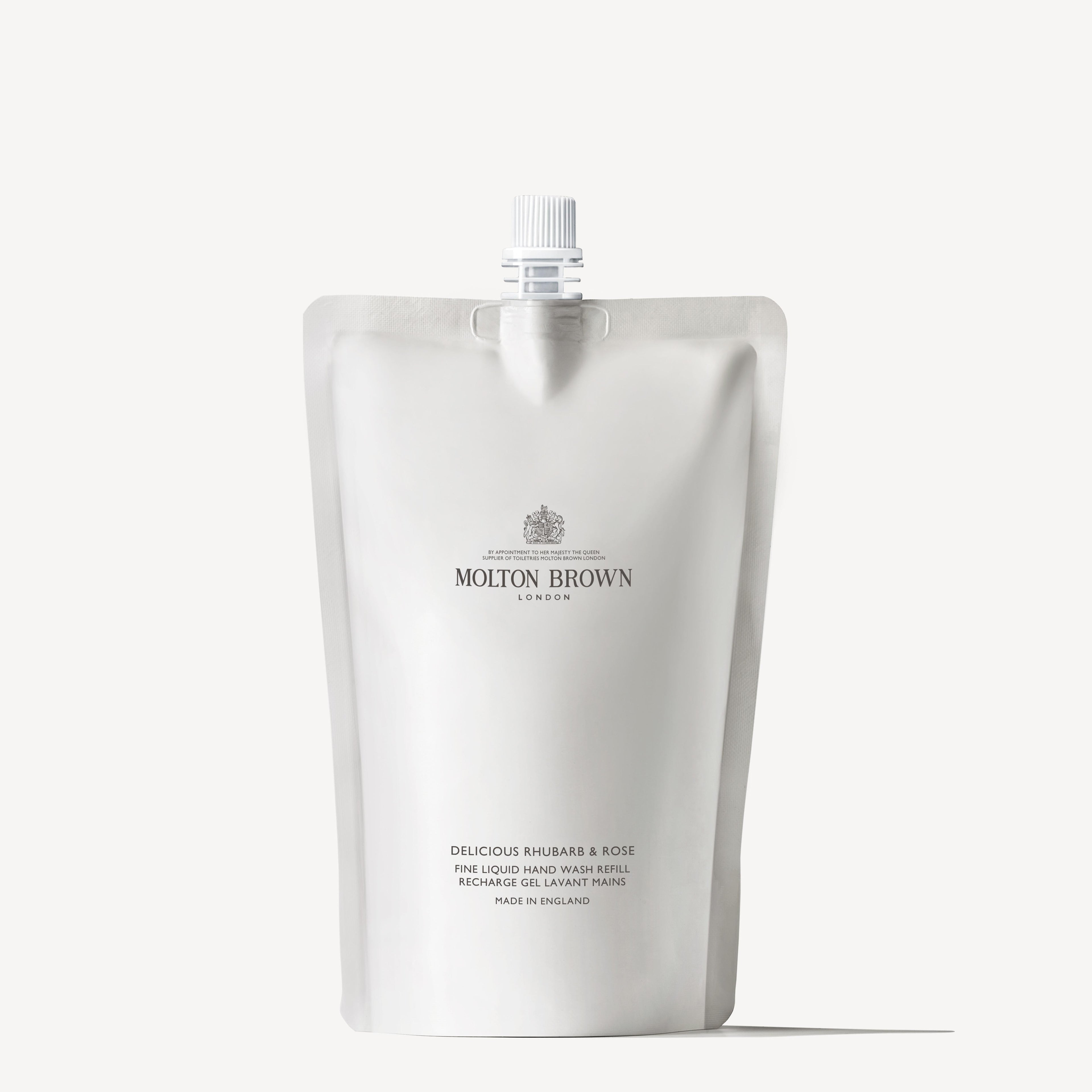 A white, minimalist MoltonBrown Cyprus refill pouch of hand wash, featuring a spout at the top. The packaging is labeled Delicious Rhubarb & Rose and emphasizes its sustainable design. Elegant text detailing the product’s features is printed below the brand name.