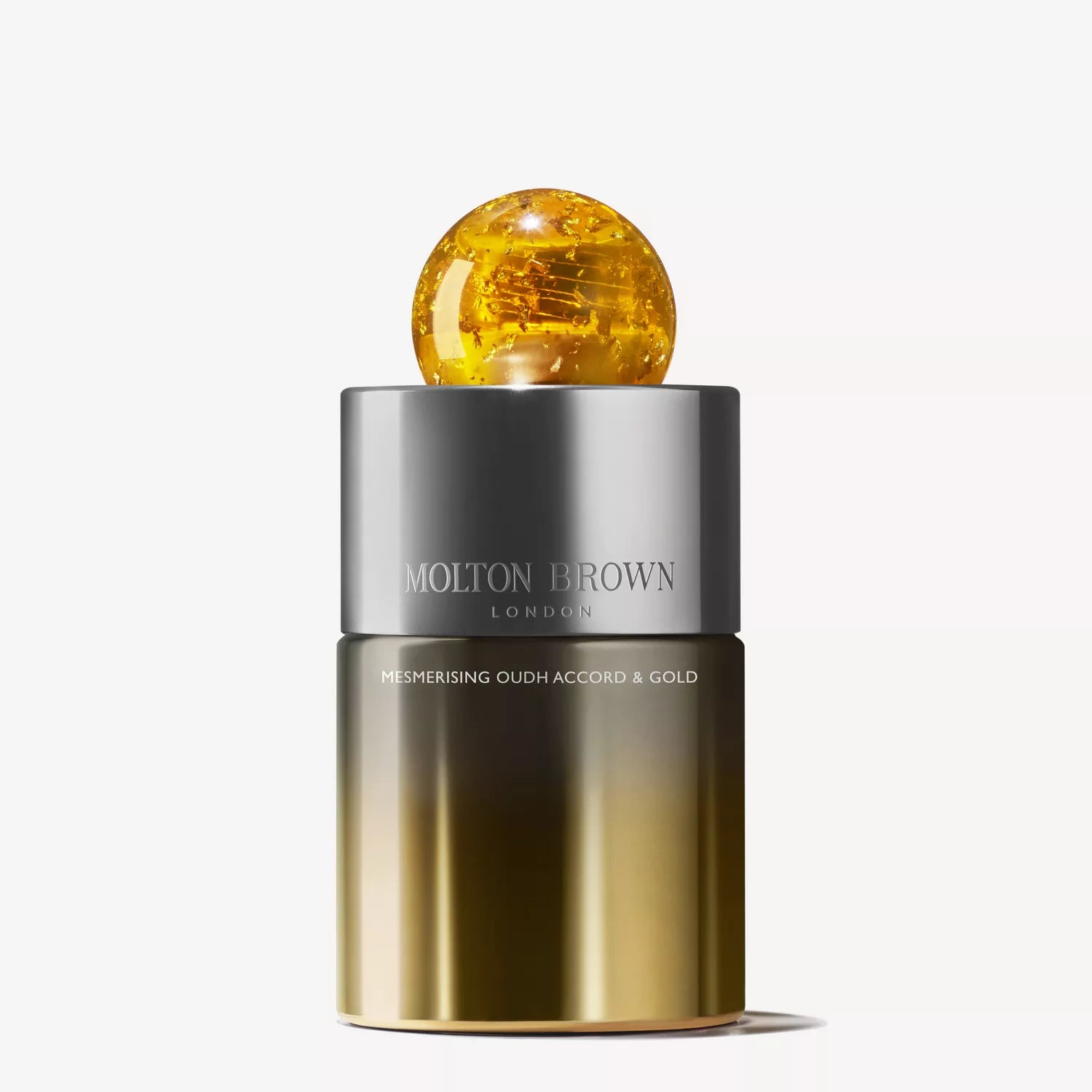 A MoltonBrown Cyprus Limited Edition Mesmerising Oudh Accord & Gold Eau de Parfum 100ml, featuring a metallic gold-silver gradient bottle with a round amber cap.