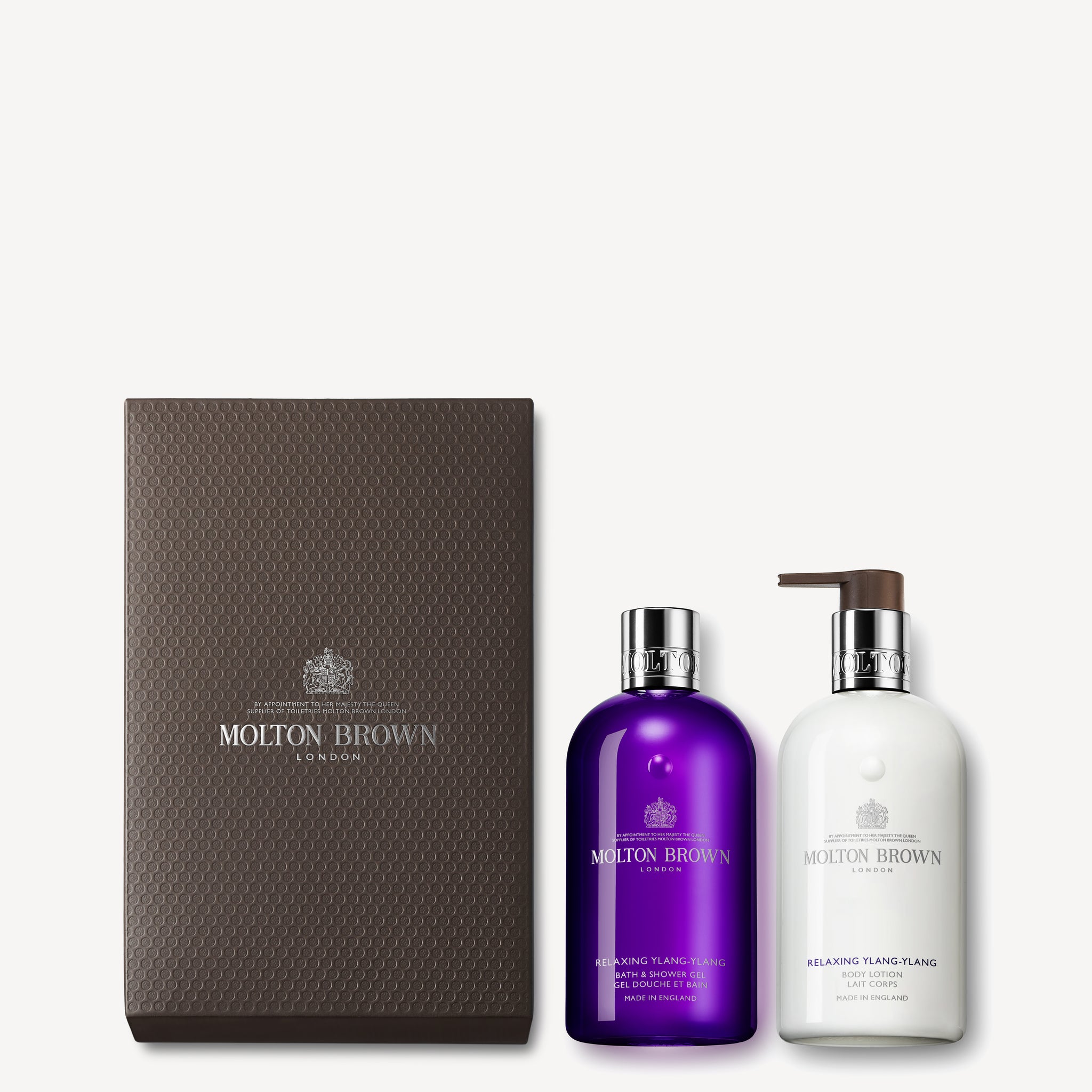 This sophisticated gift set from MoltonBrown Cyprus includes the Relaxing Ylang-Ylang Shower Gel in a stylish purple bottle, paired with a matching white body lotion featuring a convenient pump. The set is elegantly packaged in dark brown wrapping, embellished with the iconic Molton Brown logo.