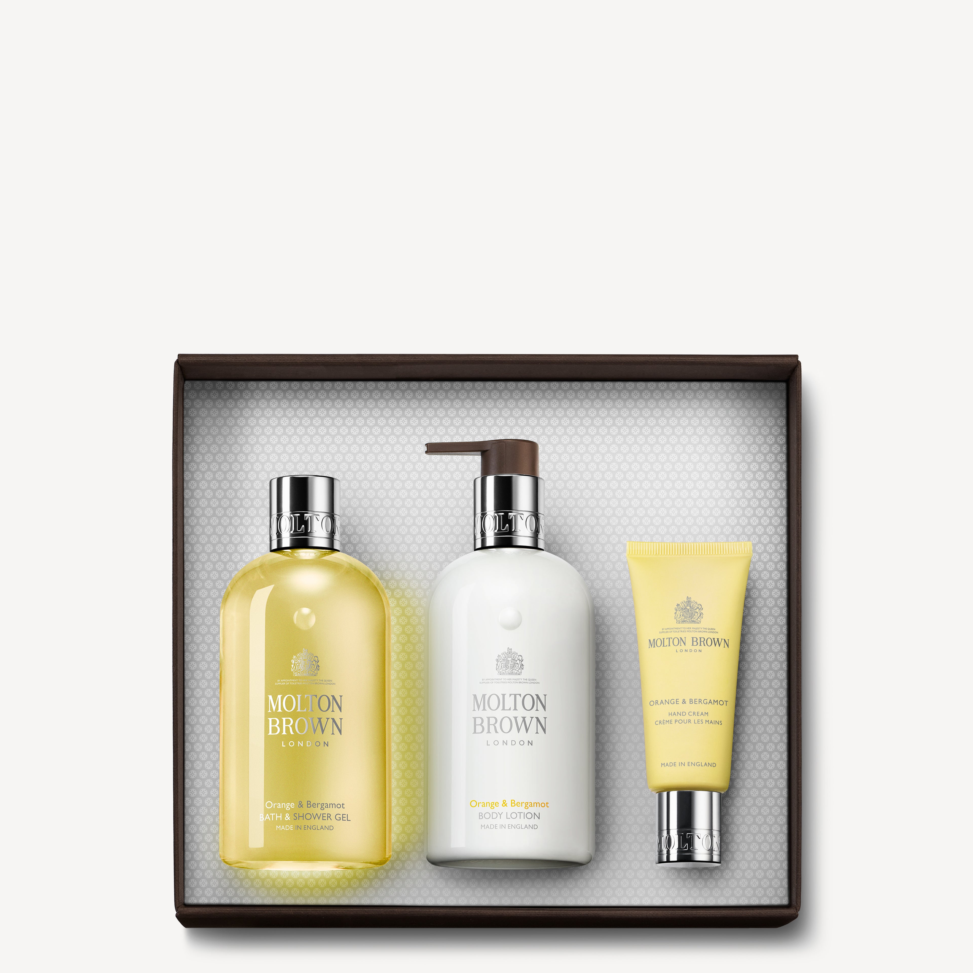 The Orange & Bergamot Pamper Gift Set by MoltonBrown Cyprus offers a luxurious collection featuring bath and shower gel, body lotion, and hand cream infused with Neroli Flower. The set is beautifully packaged in a white box with an elegantly textured interior.