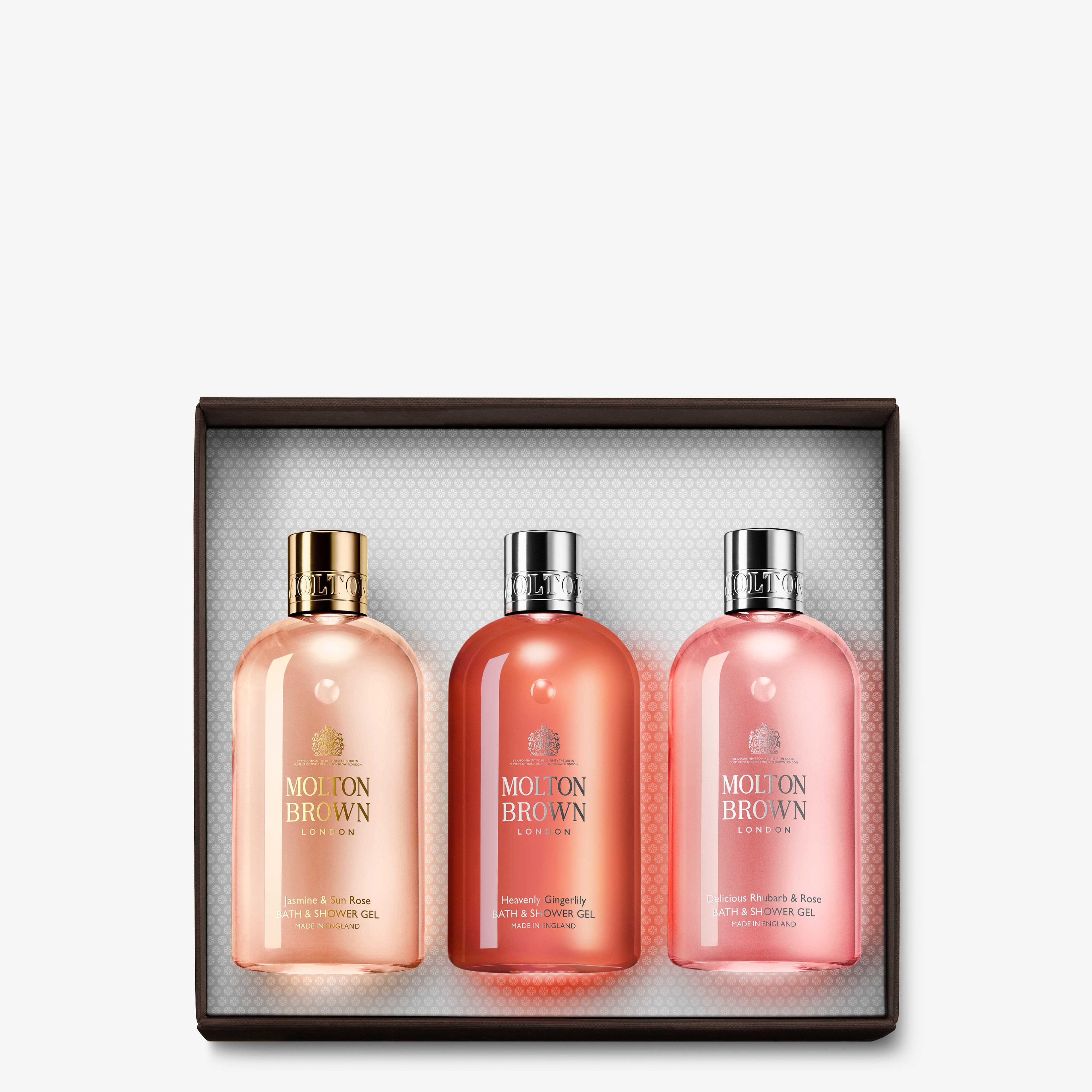 The Floral & Fruity Bathing Gift Set by MoltonBrown Cyprus showcases three Bath & Shower Gels in a pink-themed packaging, with the bottles elegantly displayed against a textured white background inside the gift box.