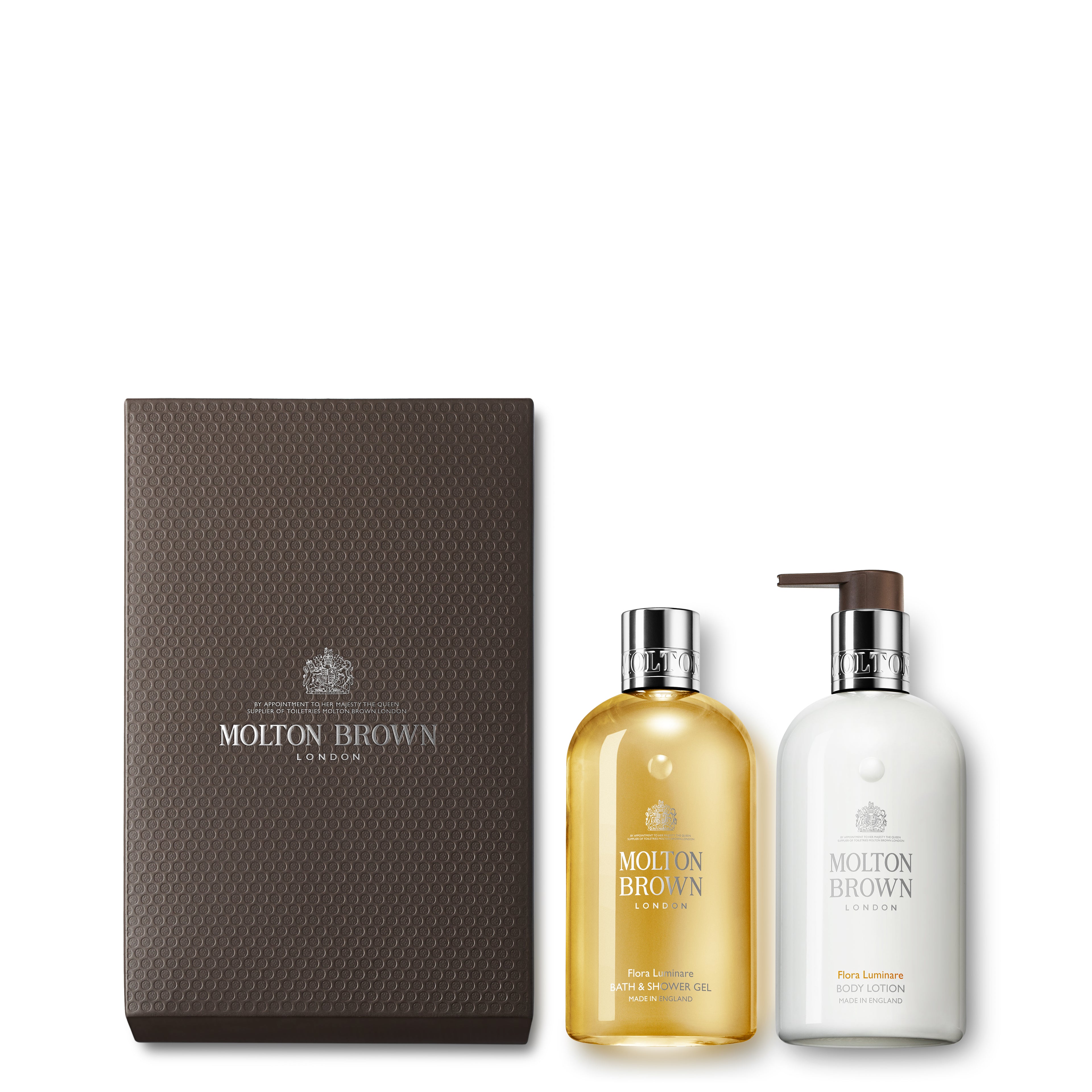 The Flora Luminare Gift Set by MoltonBrown Cyprus includes two elegant bottles within a textured brown box: a clear yellow bath & shower gel and a white body lotion with a convenient pump dispenser. Both feature silver caps and showcase the distinctive MoltonBrown Cyprus branding.