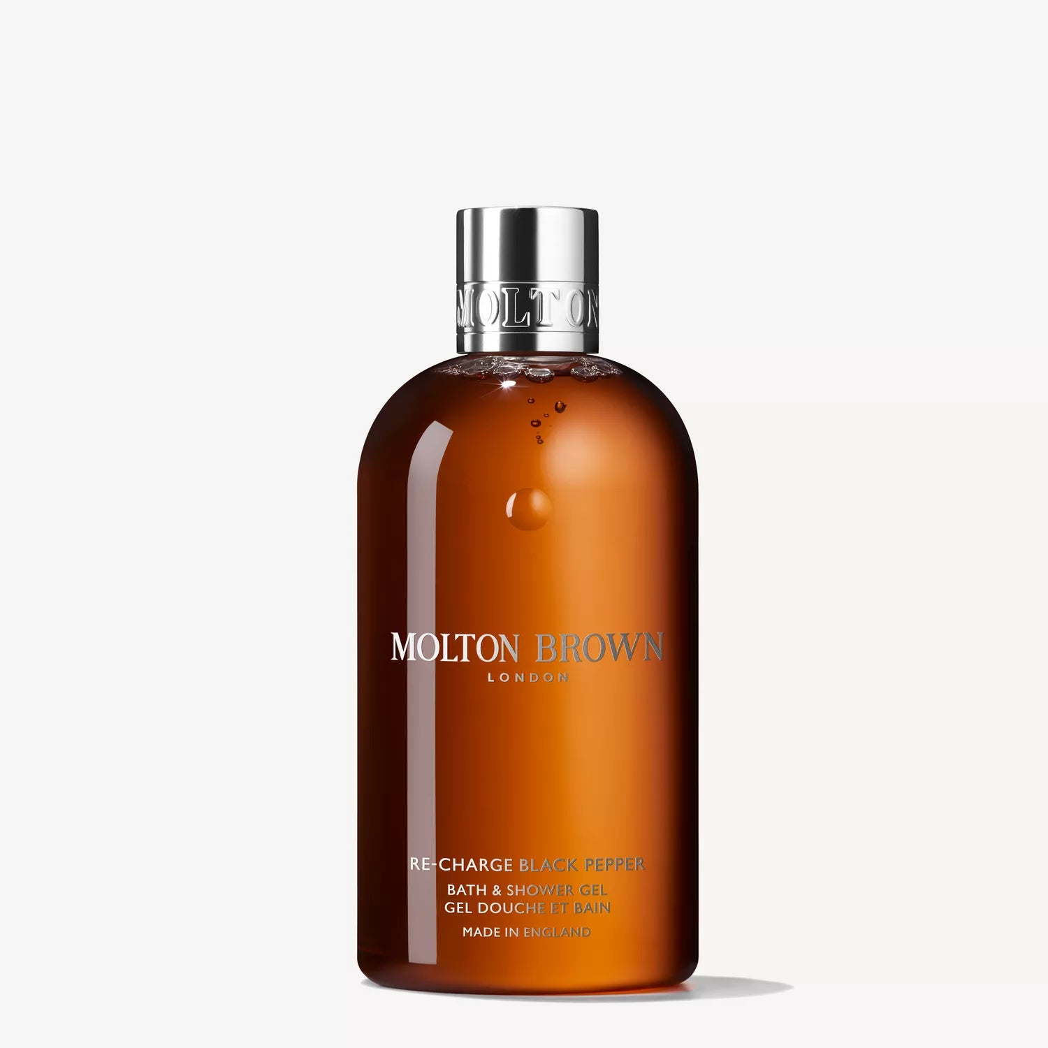 A brown bottle of MoltonBrown Cyprus Re-charge Black Pepper Fragrance Gift Set with a silver cap stands against a white background. The label features black pepper and vetiver notes in white and gold detailing.