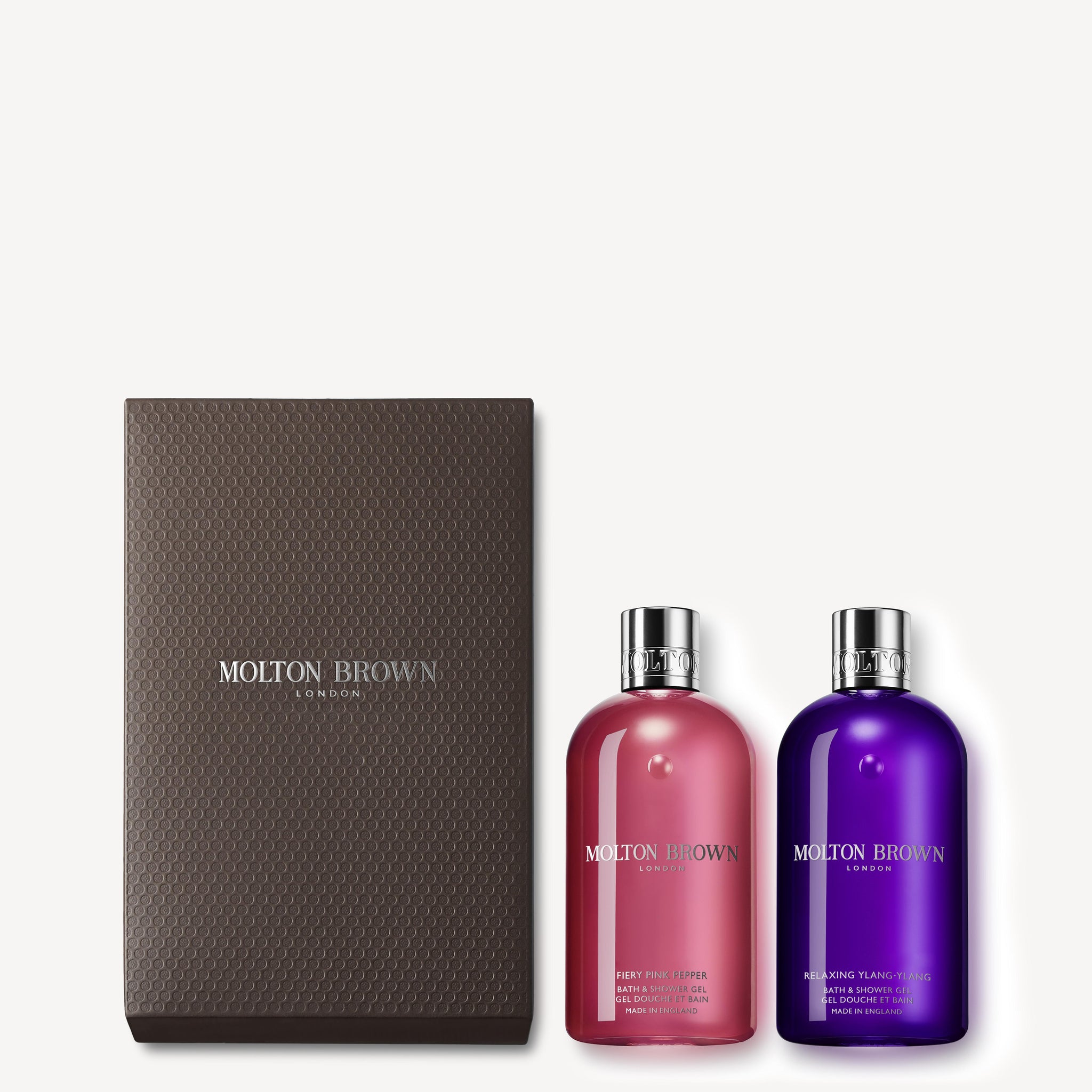 A luxurious gift box from MoltonBrown Cyprus contains the Fiery Pink Pepper & Ylang-Ylang Shower Gel Gift Set, elegantly displayed in vibrant pink and purple bottles.